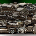 In questa immagine si possono vedere una serie di auto accumulate come in una demolizione osservate con disprezzo da 2 gatti
